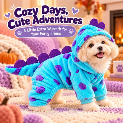 Small dog wearing cozy hooded turquoise monster pajamas indoors